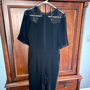 Express jump suit. Lace arm detail. Zipper back. Size S